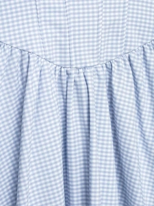 Détail du tissu vichy bleu et blanc avec de fins fronces et des coutures précises