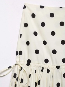 Close-up of polka dot fabric detail showing drawstring and stitched pleated hem