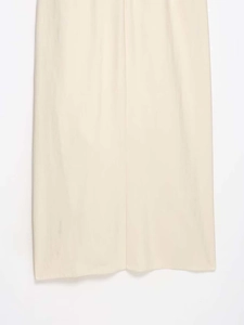 Close-up of beige summer dress hem with woven texture and ruffle detailing