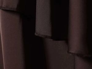 Macro detail of high-quality brown satin fabric with professional hem stitching