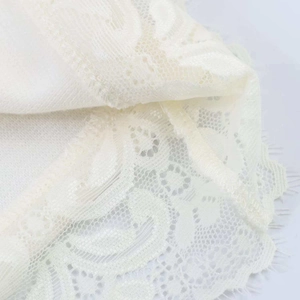 Gros plan sur tissu de dentelle florale blanche avec bords festonnés délicats
