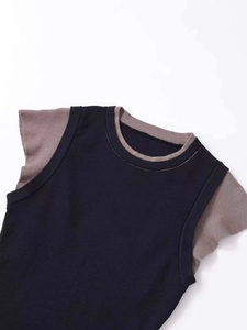 Close-up of contrast knit top with brown short sleeves and black sleeveless vest