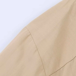 Gros plan sur le tissu de la robe kaki montrant les coutures et la texture du tissage