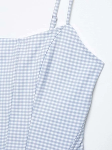 Détail de la robe vichy bleu et blanc avec fines bretelles et boucles argentées
