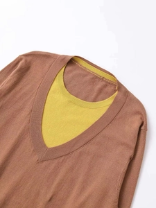 Close-up of knit top featuring a brown V-neck over a vibrant yellow round collar detail