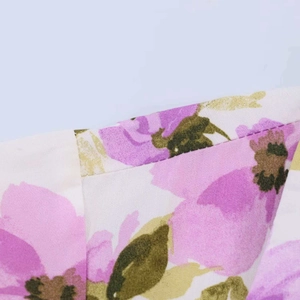 Detailed macro view of floral print fabric with purple flowers and clean stitching