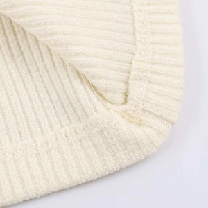 Detailed macro view of cream rib-knit fabric texture and high-quality stitching on a tank top
