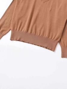 Detailed view of the brown knit sweater featuring a ribbed hem and fine knit texture