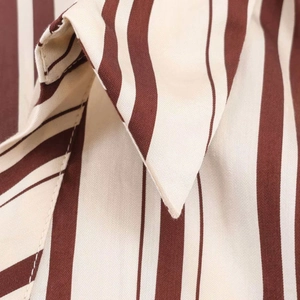 Close-up detail of cream and brown striped fabric with high-quality stitching texture