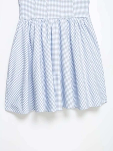 Détail d'une robe vichy bleu et blanc montrant la taille froncée et le tissu plissé