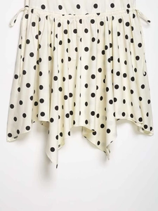 Detailed view of polka dot skirt with adjustable drawstring waist and asymmetric hemline