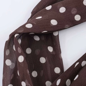 Detailed close-up showing the soft drape and white polka dots on brown chiffon fabric