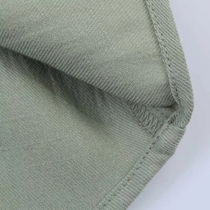 Detailed close-up showing precise internal stitching and hemming on light green fabric
