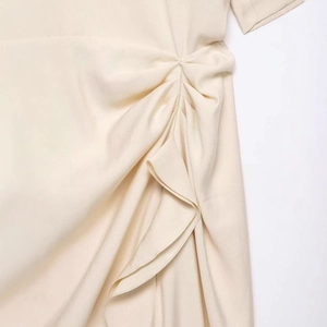 Chic apricot summer dress featuring lateral ruching details and elegant ruffle hem finishes
