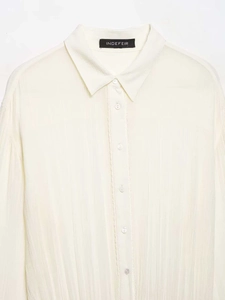 Close-up of cream pleated long sleeve shirt featuring a refined vertical texture and buttons