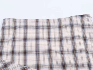 Detail of classic plaid pattern skirt featuring waist tailoring and invisible side zipper