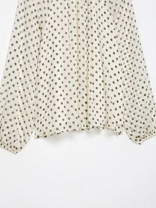Detail der Polka-Dot-Bluse mit leichtem Chiffonstoff und gerafften Ärmelbündchen