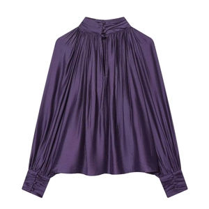 Detail of elegant pleated deep purple satin blouse featuring a back opening and button cuffs