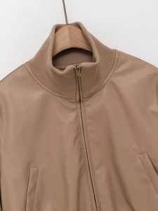 Detail of camel PU leather jacket showing the stand collar and metal zipper closure