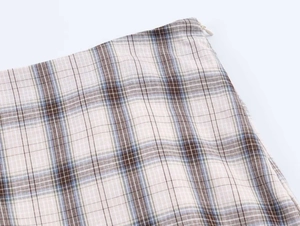 Detailed view of plaid skirt waistline featuring a discrete side invisible zipper