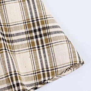 Macro detail of asymmetric plaid fabric in olive and khaki with cotton linen texture