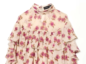 Detail of ruffled floral chiffon shirt with stand collar and elegant pearl buttons