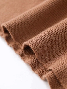 Close-up of premium brown ribbed knit fabric showing soft texture and high-density material