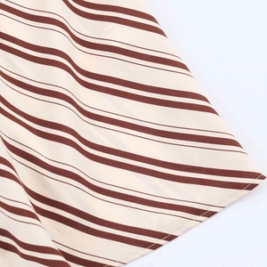 Close-up of brown and cream striped fabric with detailed stitching and soft texture