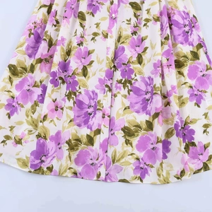 Detail of floral print dress with purple flower pattern and vertical button closure