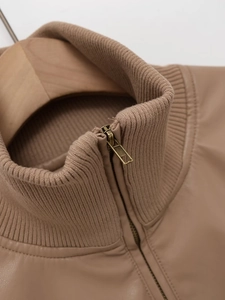Close-up of khaki leather jacket featuring a ribbed stand collar and vintage metal zipper