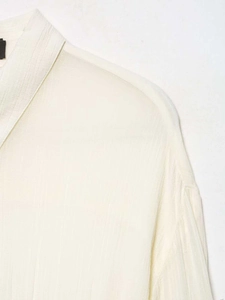 Detail of white semi-transparent chiffon fabric with vertical texture on a long sleeve shirt
