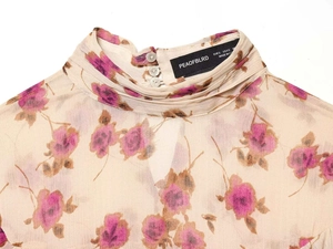 Detail of high neck chiffon top with floral print and button closure on back