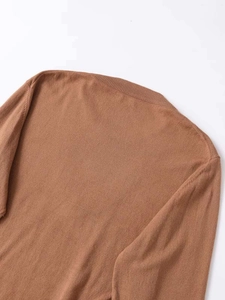 Close-up of ribbed crewneck and soft fine knit texture on a brown knitted top