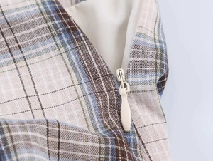 Close-up of invisible zipper detail on premium plaid fabric with classic woven texture