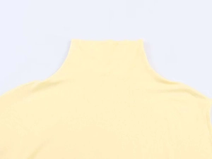 Detail of light yellow knit top featuring a mock neck collar and fine ribbed texture