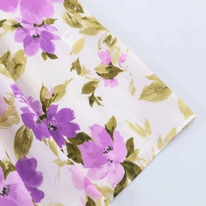 Detailed view of the purple floral print fabric and neat hem stitching of the dress