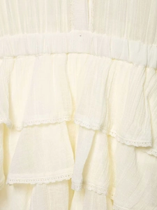 Detail of layered ruffles and delicate white lace trim on textured summer dress fabric