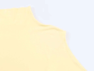 Detail shot of pale yellow knit fabric texture and high neckline stitching