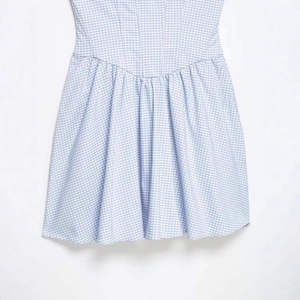 Robe d'été à carreaux vichy bleu et blanc avec taille en V et jupe à plis élégants