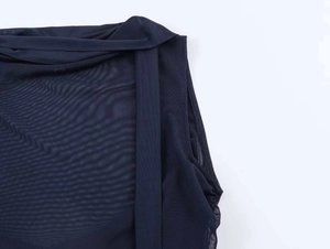 Macro detail of dark blue sheer mesh fabric with layered texture on a slim vest