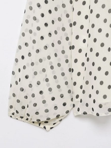 Detail der weißen Polka-Dot-Chiffonbluse mit Plissee-Stoff und elastischen Bündchen