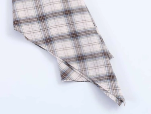 Close-up of beige plaid fabric with blue stripes showing stitching and woven texture