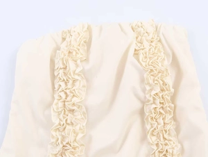 Detail shot of cream midi dress featuring parallel vertical pleated ruffle decorations