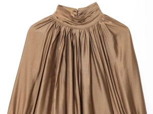 Makroaufnahme einer dunkelbraunen Satin-Bluse mit Plissee-Struktur und hohem Kragen-Design