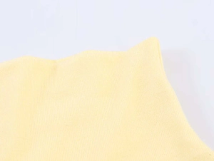 Detailed macro view of the light yellow ribbed knit fabric texture and elastic stitch
