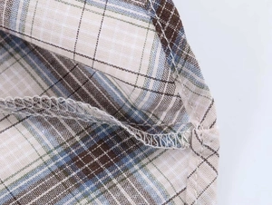 Macro view showing high-quality stitching and plaid fabric texture of the mini skirt