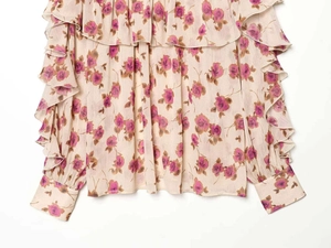 Close-up of floral print chiffon shirt featuring layered ruffles and buttoned cuffs