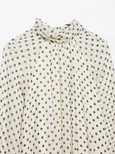 Detailansicht der gepunkteten Chiffon-Bluse mit elegantem Stehkragen und Falten-Design