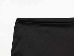 Gros plan sur la taille en satin noir et les coutures détaillées de cette jupe courte chic