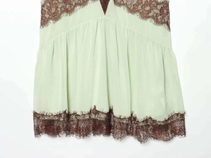 Detail of mint green chiffon camisole with brown eyelash lace trim and embroidery